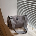 Grey nylon dumpling bag with double zippers and wide crossbody strap in a minimalist setting - Gray