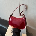 Bolso de hombro vintage de charol burdeos brillante con herrajes dorados en la mano - Rojo
