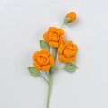 Macro detail of three handmade crochet roses with vibrant orange petals and green leaves - Xue Wu 3-Head Barbie Rose Stem / Orange