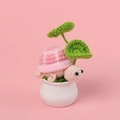 Tortuga de ganchillo artesanal en maceta cerámica sobre fondo rosa suave - Rosa