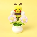 Detail of handmade crochet bee on a pink flower in a white ceramic pot with yellow background - Bee Gathering Nectar - Purple Puff Flower