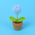 Handmade crochet mini tulip in light blue with green leaves in a brown woven pot - Blue