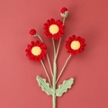 Macro detail of hand-knitted crochet daisy bouquet featuring vibrant red yarn petals - Red