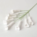 Macro-detail van handgehaakte witte klokjesbloemen met getextureerde garenblaadjes - Wit