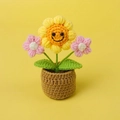 Handgefertigte gehäkelte Sonnenblume im Topf mit lächelndem Gesicht auf Gelb - Mittelgroße Mini-Topfpflanze / Smiley-Sonnenblume mit rosa Blüten