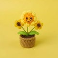 Nahaufnahme der handgehäkelten Sonnenblume im Topf mit lächelndem Gesicht als Deko - Mittelgroße Mini-Topfpflanze / Smiley-Sonnenblume mit tiefgelben Blüten