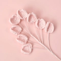 Close-up of handmade crochet lily of the valley in pale pink with delicate yarn texture - Pink