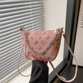 Pink lychee texture bucket bag with bear print and silver chain held by a window - Pink