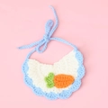 Dettaglio del bavaglio in maglia fatto a mano bianco con bordi blu e piccola carota - Carota