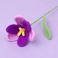 Close-up of hand-crocheted purple tulip flower with yellow stamens and green leaf - Open Tulip Stem / Gradient Deep Purple
