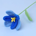 Detail of hand-crocheted gradient blue tulip with yellow stamen and green knitted stem - Open Tulip Stem / Gradient Royal Blue