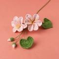 Detail view of handmade crochet lily with pink petals and heart-shaped green leaves - Pink