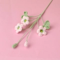 Detailed handmade crochet flower bouquet with pink blossoms and green stems on a pink backdrop - 3-Head Shamrock Flower Branch / Pink