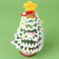 Detail eines handgestrickten Mini-Weihnachtsbaums mit bunten Pompons und Holzbasis - Verlauf Grün