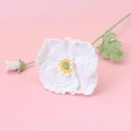 Close-up of handmade crochet poppy flower with white petals and yellow pistil - White