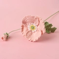 Detalle de una flor de amapola rosa hecha a mano a ganchillo con tejido artesanal - Rosa