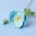 Macro detail of hand-knitted blue poppy flower featuring intricate crochet textures - Gradient Blue