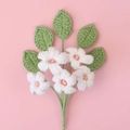 Macro view of handmade crochet flowers with five white petals and pink centers - White