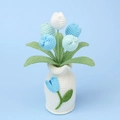 Nahaufnahme eines handgehäkelten Tulpenstraußes in einer gestrickten Vase als Deko - Verlauf Blaue Tulpe - Große Weiße Vase (Modell Z)
