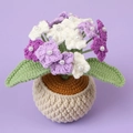 Top macro view of handmade crochet hydrangea petals with white pearls and green leaves - Gradient Purple