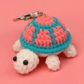 Close-up of handmade crochet turtle keychain with detailed pink and green yarn texture - Blue