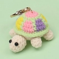 Macro detail of a colorful handmade crochet turtle keychain with a golden metal clasp - Green