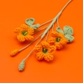 Handmade crochet shamrock bouquet with three orange flowers and green stems on orange background - 3-Head Shamrock Flower Branch / Orange