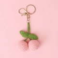 Detail of pink handmade crochet cherry keychain with green leaves and golden clasp - Pink Cherry