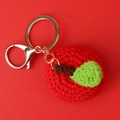 Detailed close-up of handmade crochet apple keychain with green leaf and golden clip - Red Apple