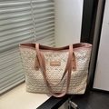 Lace woven straw tote bag with pink leather trim and gold brand plaque on a white table - Pink