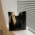 Black tote bag with white contrast stitching, silk scarf handle, and gold hardware - Black