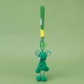 Close-up of handmade green crochet frog keychain with metal hook and small bell accessory - Frog With Hanging Legs / Green