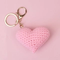 Close-up of a pink handmade crochet heart charm with a polished gold keychain fastener - Pink