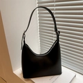 Sac sous le bras noir minimaliste avec boucles argentées sur fond blanc épuré - Noir