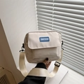 Minimalist cream nylon crossbody bag with blue logo patch and wide adjustable strap - White