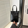 Minibolso de cuero negro brillante con correa bandolera y detalle de nudo moderno - Negro