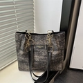 Dark gray textured tote bag with golden chain hardware and leather straps in a window setting - Black