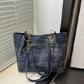 Blue denim tote bag with silver speckles and golden chain handles shown on windowsill - Dark Blue