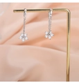 Makro-Detail von S925 Silber Blumen-Ohrringen mit Zirkonia auf champagnerfarbener Seide - Weißgold