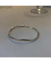 Makro-Detail der silbernen Mobius-Armspange mit gedrehtem Wellendesign und Spiegelglanz - Silberner Geometrischer Wellenstil