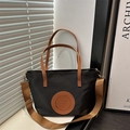 Zwarte nylon tote bag met bruine lederen handvatten en brede schouderriem bij een venster - Klein / Zwart