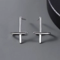 Macro shot of polished silver cross earrings with a sleek minimalist metallic finish - Cross Stud Earrings