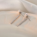 Macro shot of long drop pearl earrings with silver vertical bar set with 12 cubic zirconia - Pearl 2-Way Stud Earrings - Platinum Silver