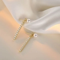 Detail of gold pearl drop earrings with micro-set zircon on white velvet fabric - Pearl 2-Way Stud Earrings - Gold