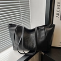 Large black leather tote bag featuring a prominent embossed B logo and slim shoulder straps - Black