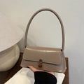 Retro khakifarbene Achseltasche mit langem Schultergurt und Bronzeschnalle in warmem Ambiente - Khaki