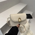 Bolso cuadrado chic de cuero crema con cierre de herradura dorado llevado en la mano - Blanco