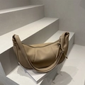 Minimalist beige crescent shoulder bag in lychee texture on grey steps scenery - Khaki