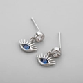 Macro detail of silver Evil Eye stud earrings with blue gemstone and sparkling zircon - White Gold Style / Blue Eye Studs-White Gold Color