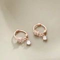 Macro-opname van roségouden bloemenoorbellen met sprankelende hangers van zirkoonsteen - Prachtige Kleine Bloemen Oorbellen-Roségoud